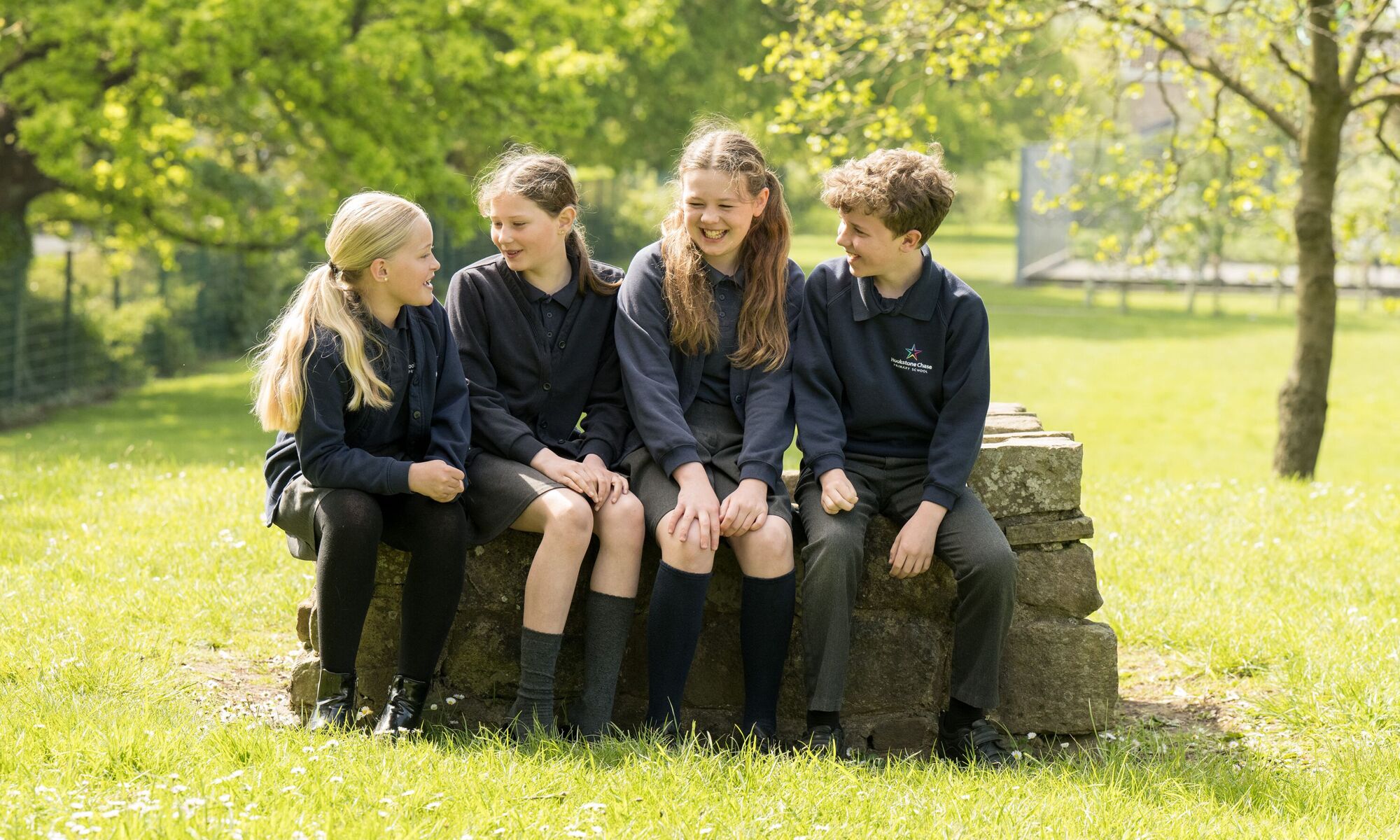 Hookstone Chase Primary School - 4 pupils sitting on a large rock