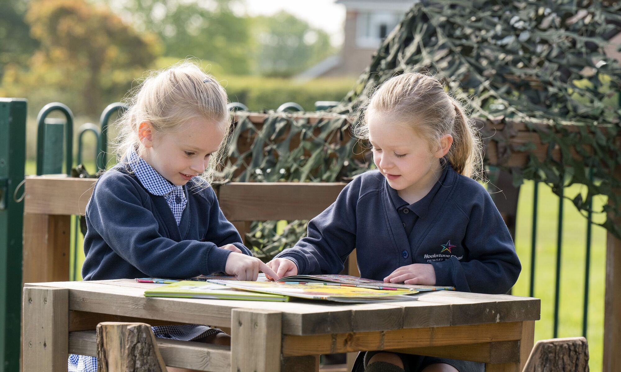 Hookstone Chase Primary School - 2 pupils reading outdoors